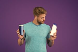 A man holding a conditioner and a shampoo