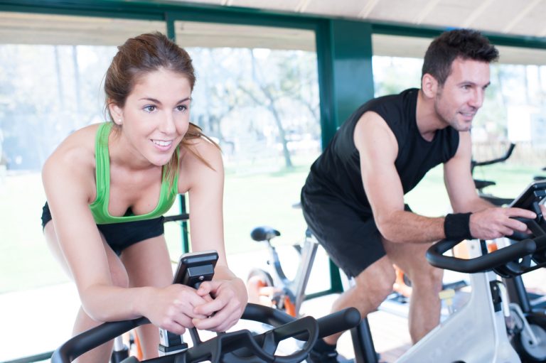 spin bike flywheel weight heavy vs light - couple working out